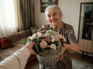 Бабушка получает корзину с цветами от внучки