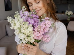 Букеты с маттиолой — девушка вдыхает сладкий аромат букета маттиолы у окна