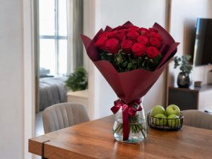 Розы 60 см — букет 25 красных роз 60 см в стеклянной вазе на столе в светлой квартире