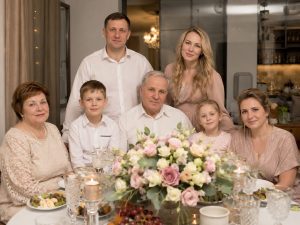 Семья за праздничным столом с букетом пастельных роз